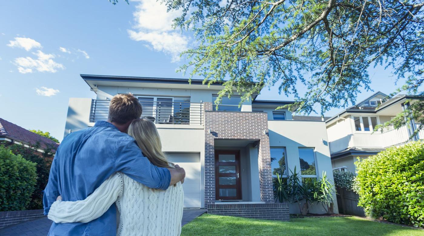 A couple looking at a modern two story home